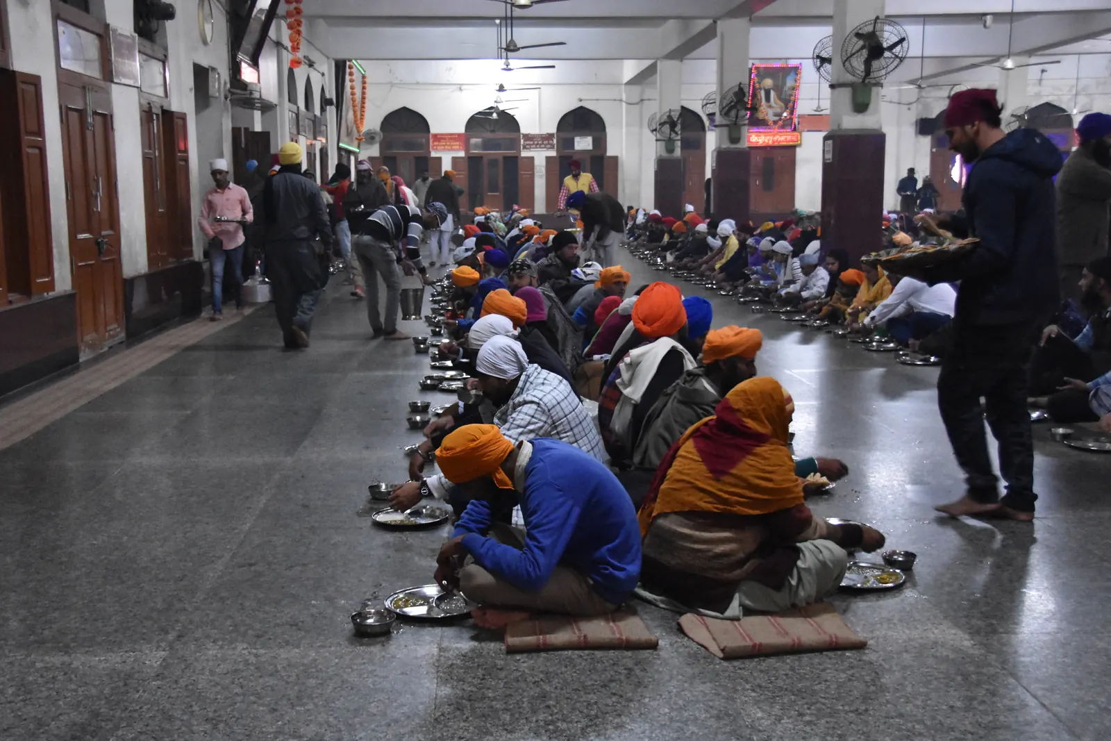 Rows of people seated for a free community meal