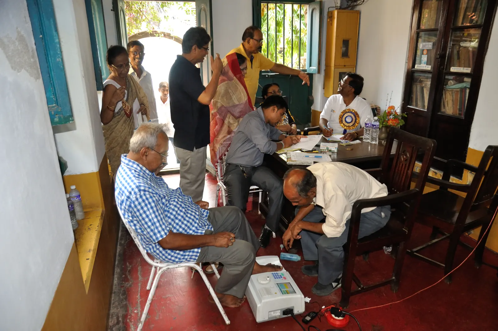 A health worker conducting a check-up for an elderly man